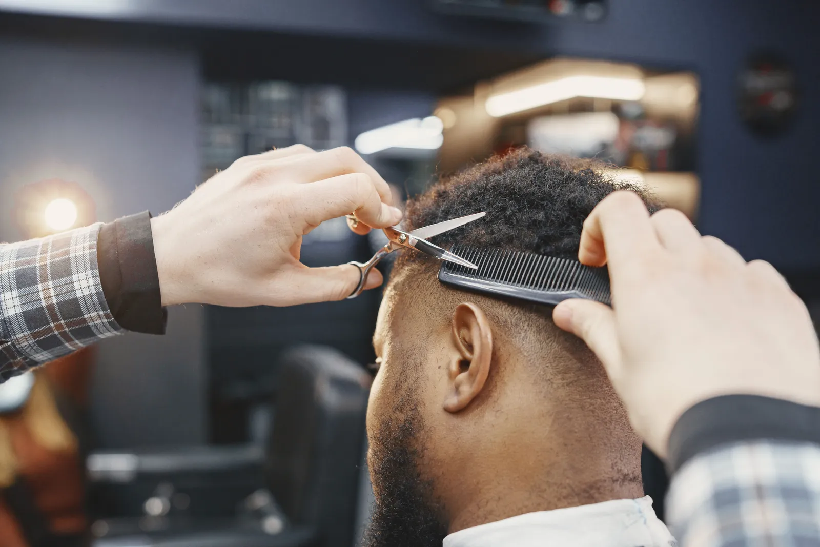 Corte à tesoura com pente, visto por trás do cliente